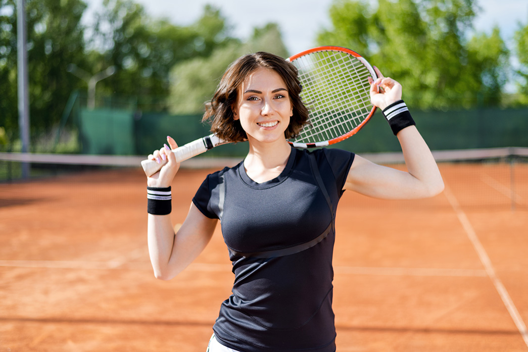 happy lady smiling lady at a tennis court